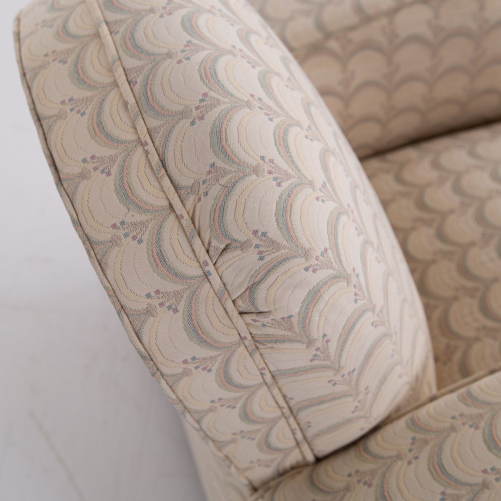 A pair of 1930s Art Deco upholstered armchairs featuring rounded arms, a scalloped fabric pattern, and small integrated casters. View XI