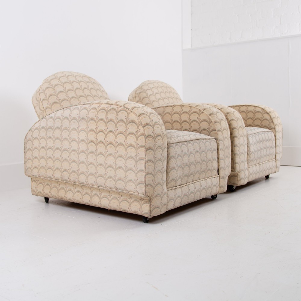 A pair of 1930s Art Deco upholstered armchairs featuring rounded arms, a scalloped fabric pattern, and small integrated casters. View XIII