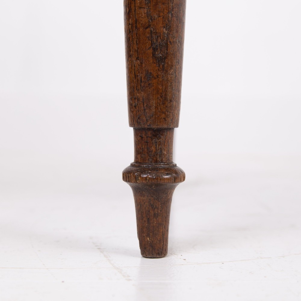 A pair of 1820s Georgian dark oak elbow chairs featuring woven rush seats, swept armrests, and turned front legs. View VIII