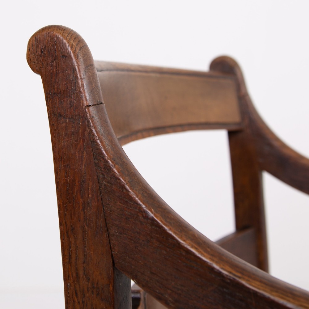 A pair of 1820s Georgian dark oak elbow chairs featuring woven rush seats, swept armrests, and turned front legs. View XI
