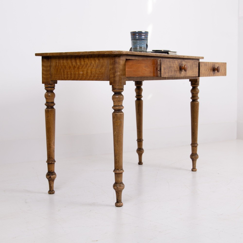 A 19th-century pine side table featuring two drawers with wooden knob handles, supported by slender turned legs. View X