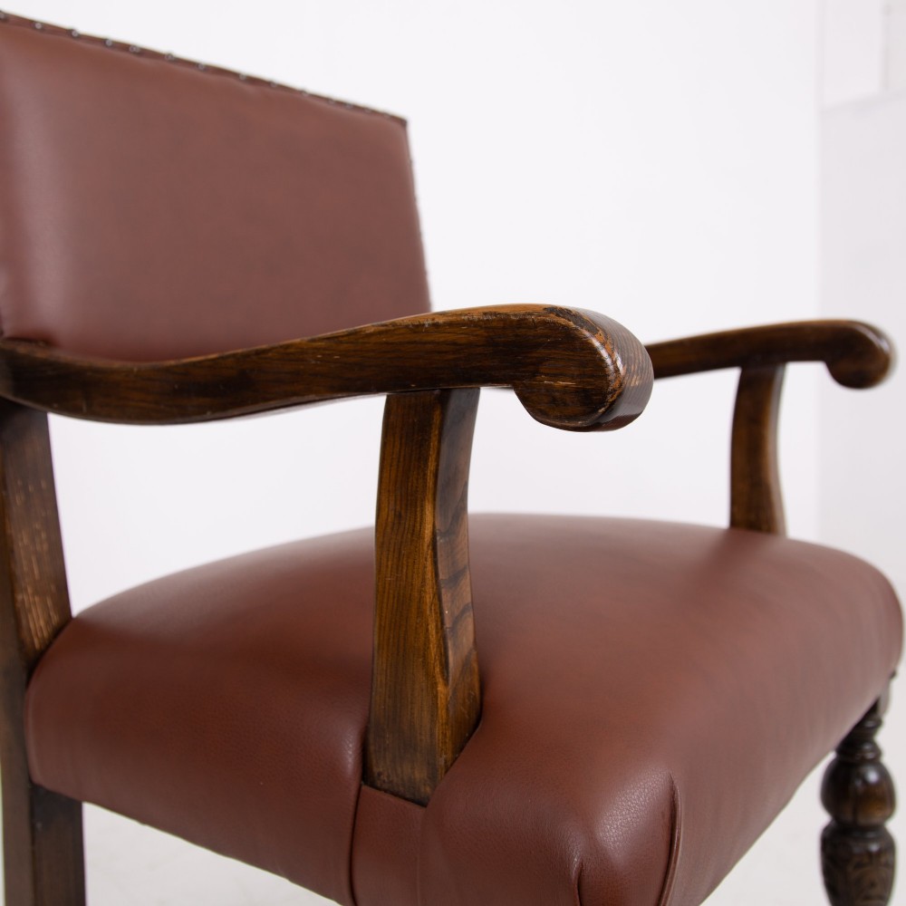 A set of six dark oak dining chairs featuring brown leather upholstered seats and backrests with brass stud detailing and turned front legs. View VIII