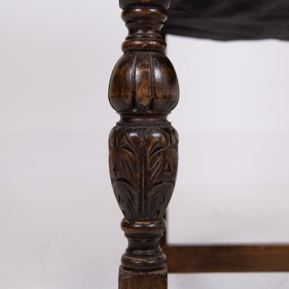 A set of six dark oak dining chairs featuring brown leather upholstered seats and backrests with brass stud detailing and turned front legs. View XI