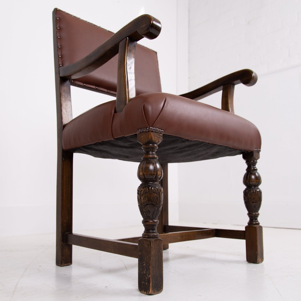 A set of six dark oak dining chairs featuring brown leather upholstered seats and backrests with brass stud detailing and turned front legs. View XII