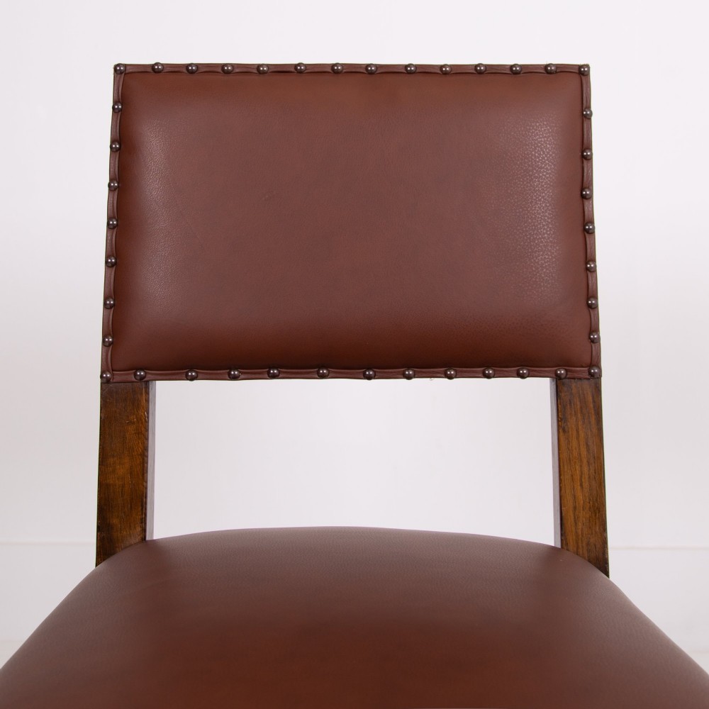 A set of six dark oak dining chairs featuring brown leather upholstered seats and backrests with brass stud detailing and turned front legs. View XV