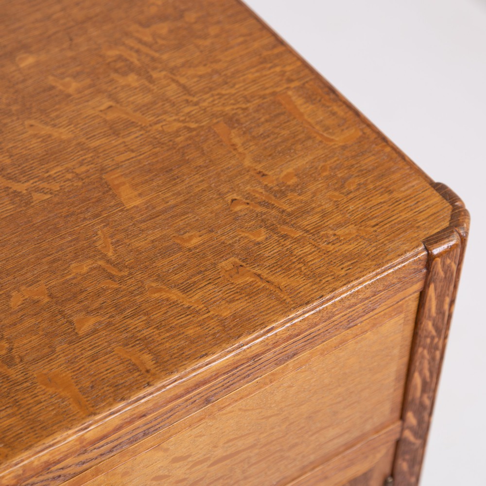 A 1930s light oak sideboard featuring three upper drawers over three panelled cupboard doors with wooden knob handles. View VII