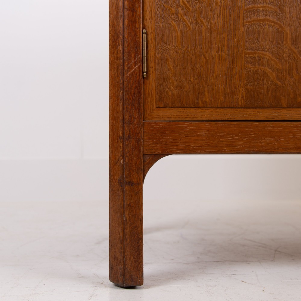 A 1930s light oak sideboard featuring three upper drawers over three panelled cupboard doors with wooden knob handles. View XI