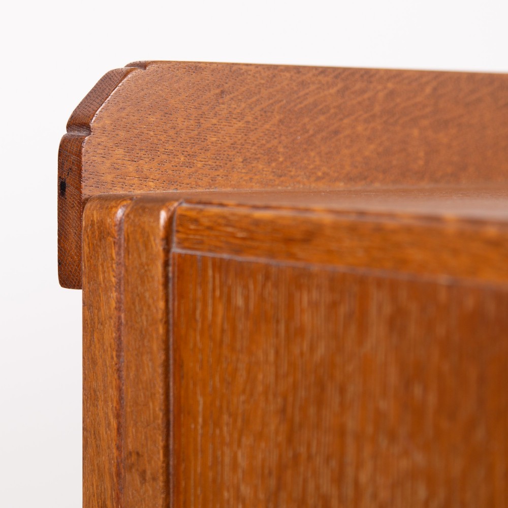 A 1930s light oak sideboard featuring three upper drawers over three panelled cupboard doors with wooden knob handles. View XV