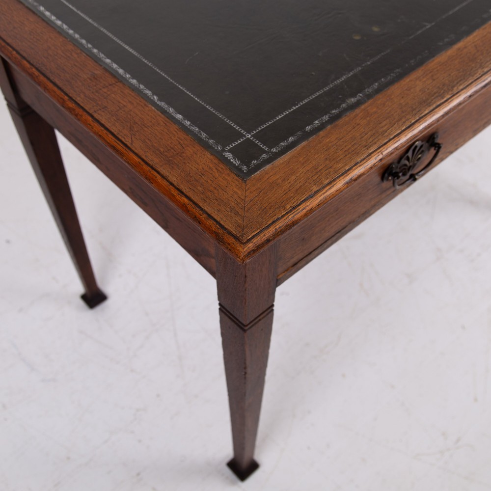 A 1920s English oak writing table featuring two frieze drawers with metal drop handles and four slender tapered legs. View VI