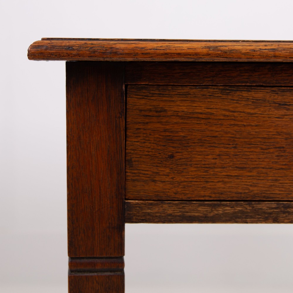 A 1920s English oak writing table featuring two frieze drawers with metal drop handles and four slender tapered legs. View XI