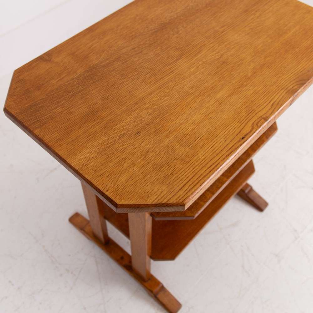 An antique Cotswold School solid oak side table featuring three rectangular shelves supported by straight uprights and sled feet. View V