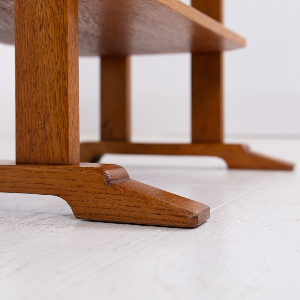 An antique Cotswold School solid oak side table featuring three rectangular shelves supported by straight uprights and sled feet. View IX