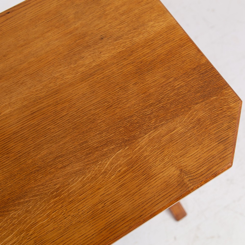 An antique Cotswold School solid oak side table featuring three rectangular shelves supported by straight uprights and sled feet. View X