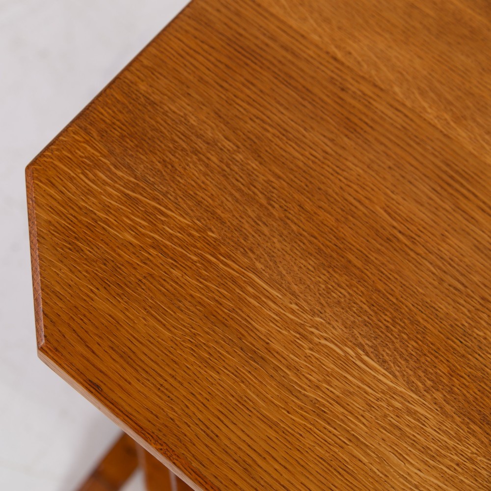 An antique Cotswold School solid oak side table featuring three rectangular shelves supported by straight uprights and sled feet. View XI