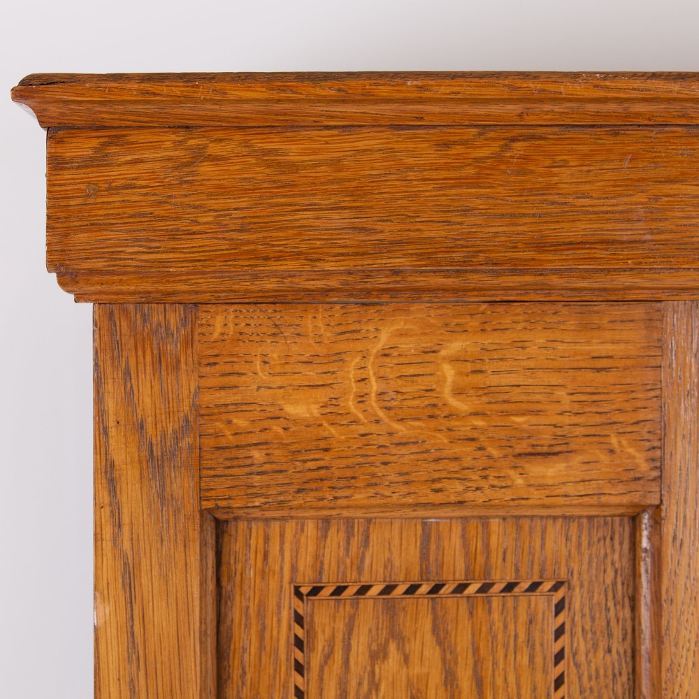An Edwardian single-door oak wardrobe featuring a central vertical mirror, recessed side panels, a single base drawer, and a stepped top cornice. View VII