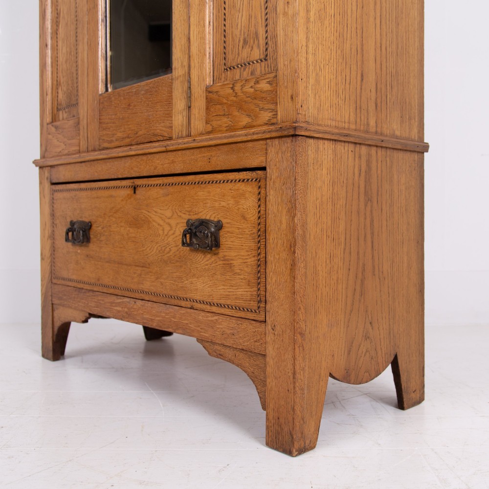 An Edwardian single-door oak wardrobe featuring a central vertical mirror, recessed side panels, a single base drawer, and a stepped top cornice. View X