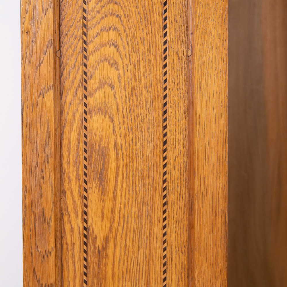 An Edwardian single-door oak wardrobe featuring a central vertical mirror, recessed side panels, a single base drawer, and a stepped top cornice. View XII