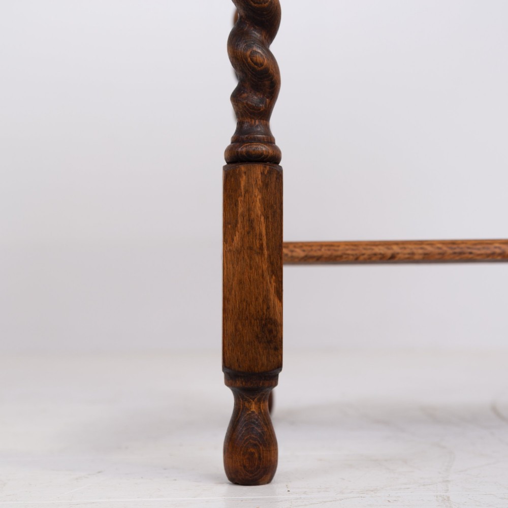 A warm brown oak side table featuring two stacked drawers with metal shell handles, four turned barley twist legs, and a low rectangular shelf. View V