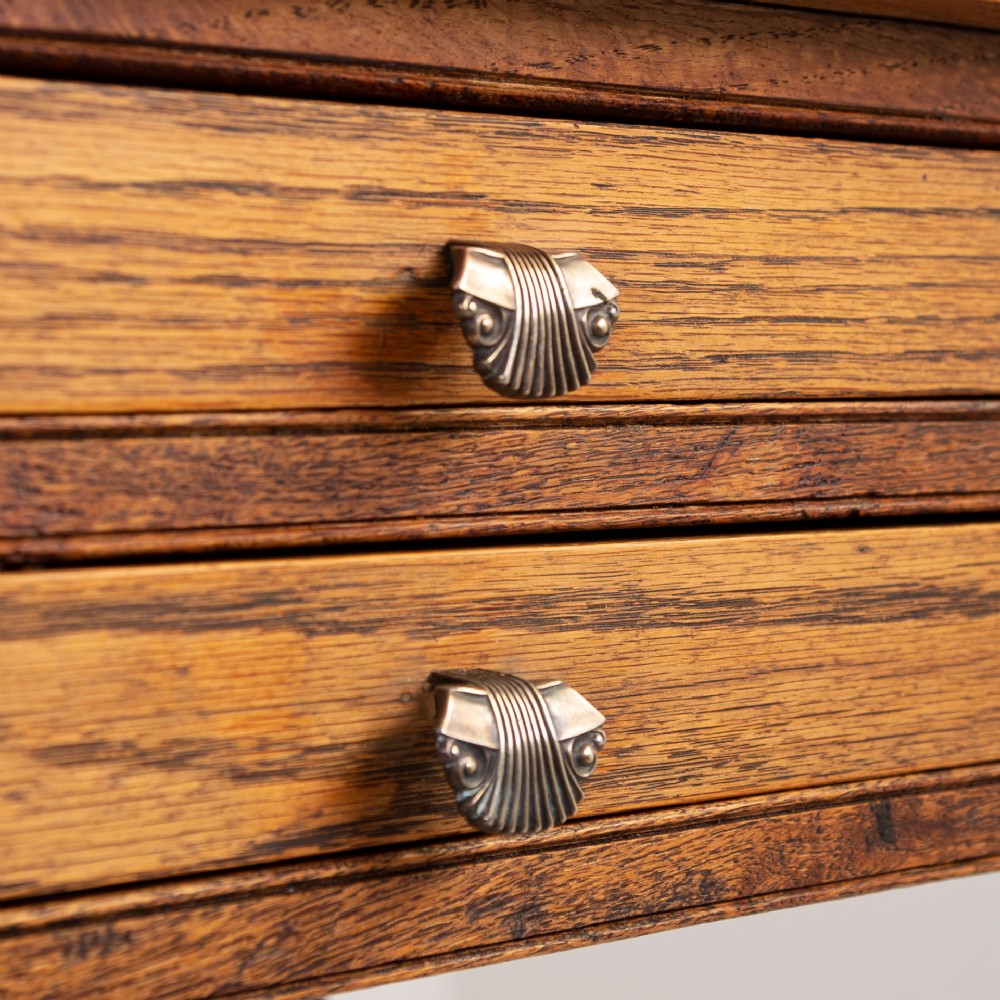 A warm brown oak side table featuring two stacked drawers with metal shell handles, four turned barley twist legs, and a low rectangular shelf. View VIII