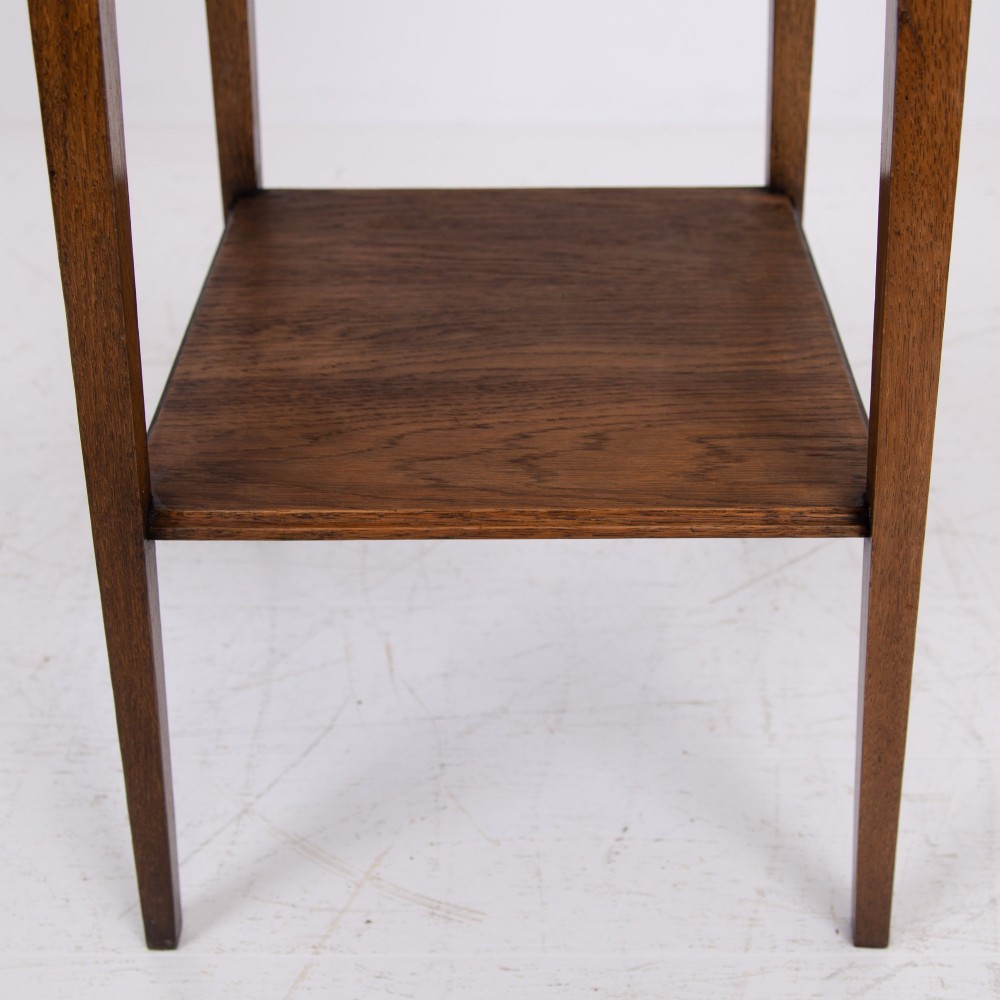 An Arts and Crafts solid oak two-tier side table with tapered legs and heart-shaped pierced motifs along the apron. View VIII