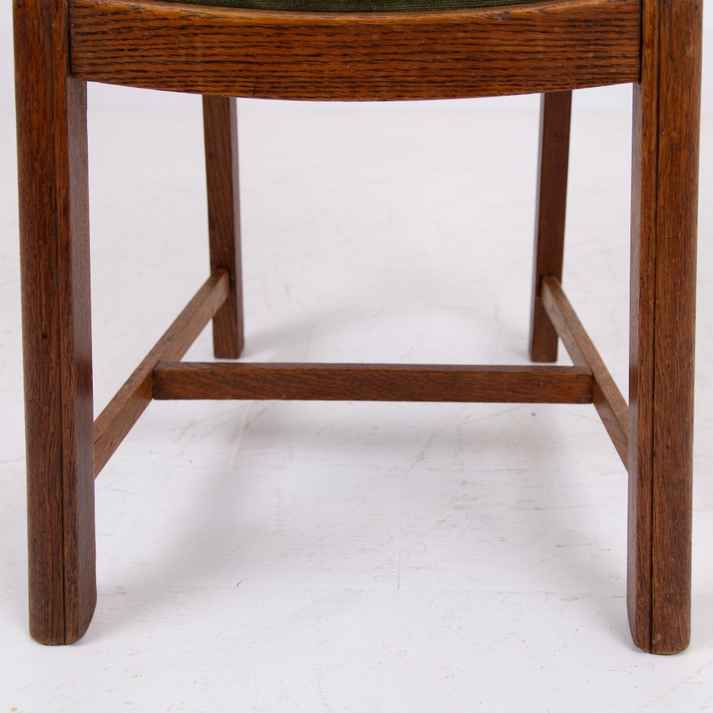 A set of four 1930s oak dining chairs featuring carved back splats, fluted top rails, and green velvet upholstered seats. View VII