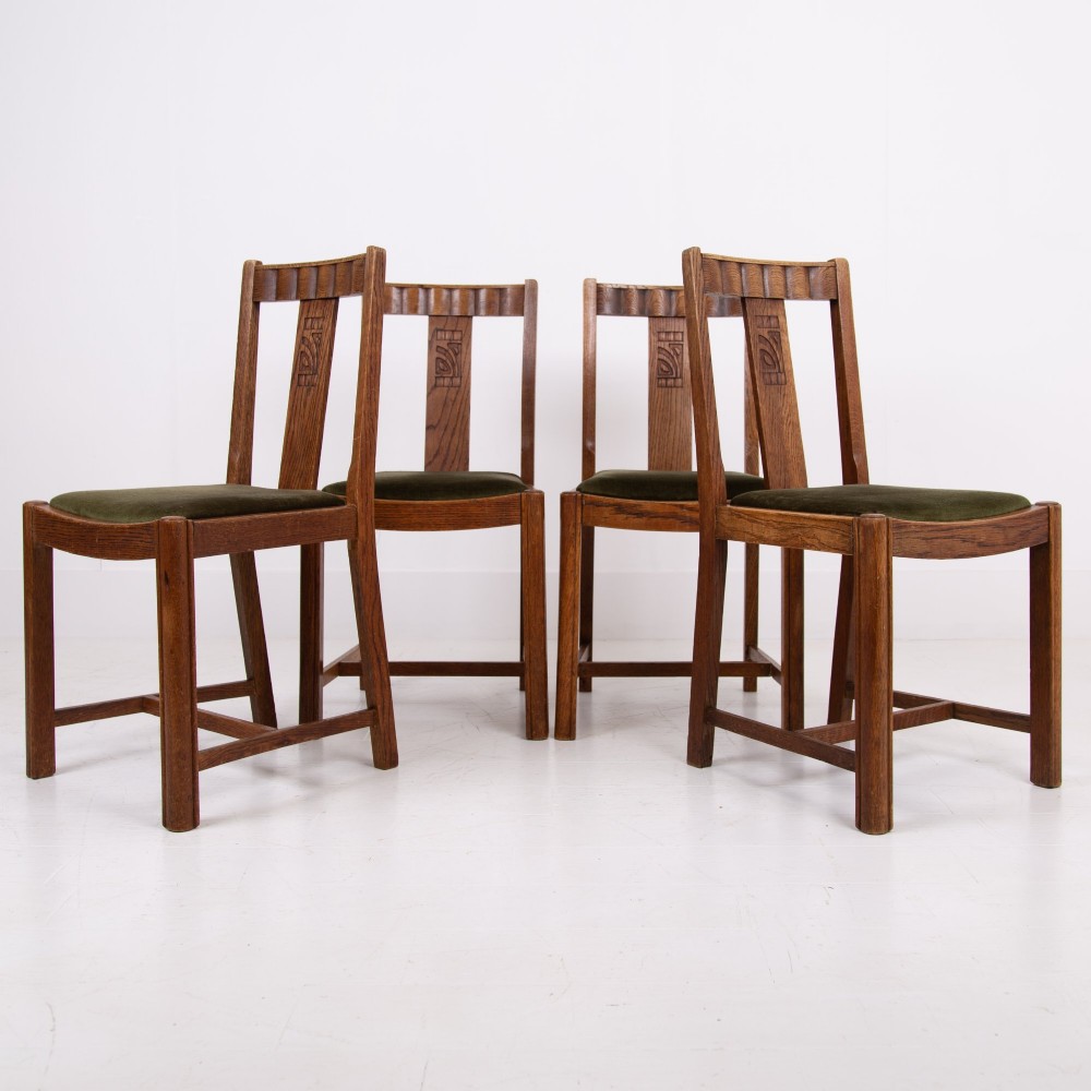A set of four 1930s oak dining chairs featuring carved back splats, fluted top rails, and green velvet upholstered seats. View VIII