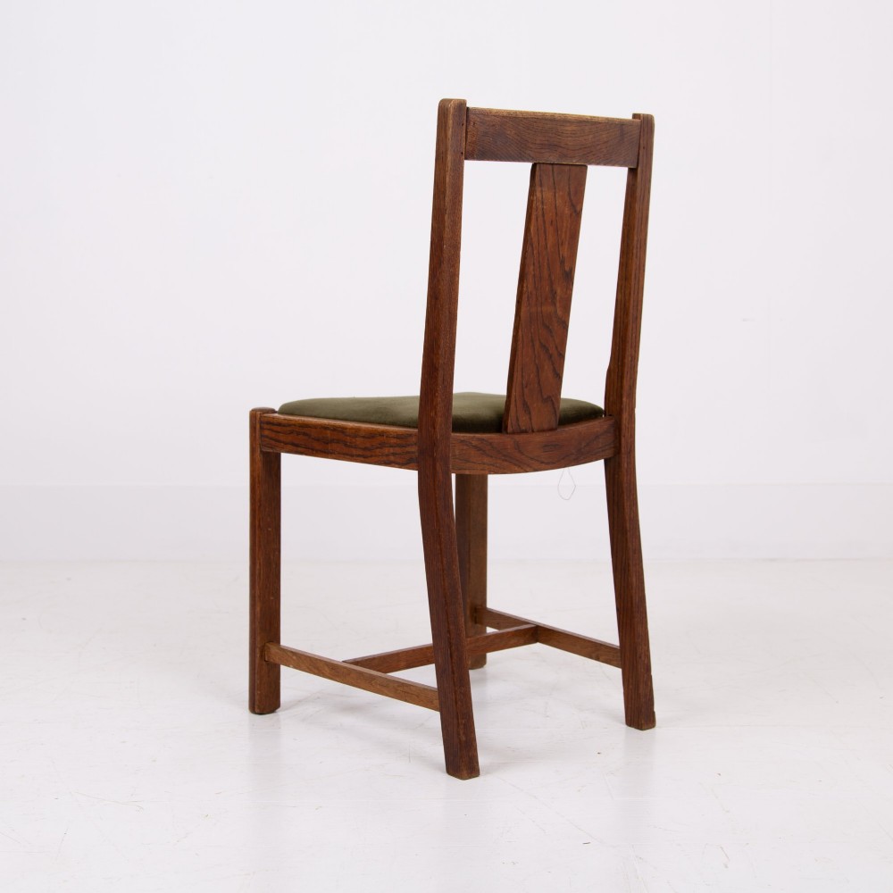 A set of four 1930s oak dining chairs featuring carved back splats, fluted top rails, and green velvet upholstered seats. View XI