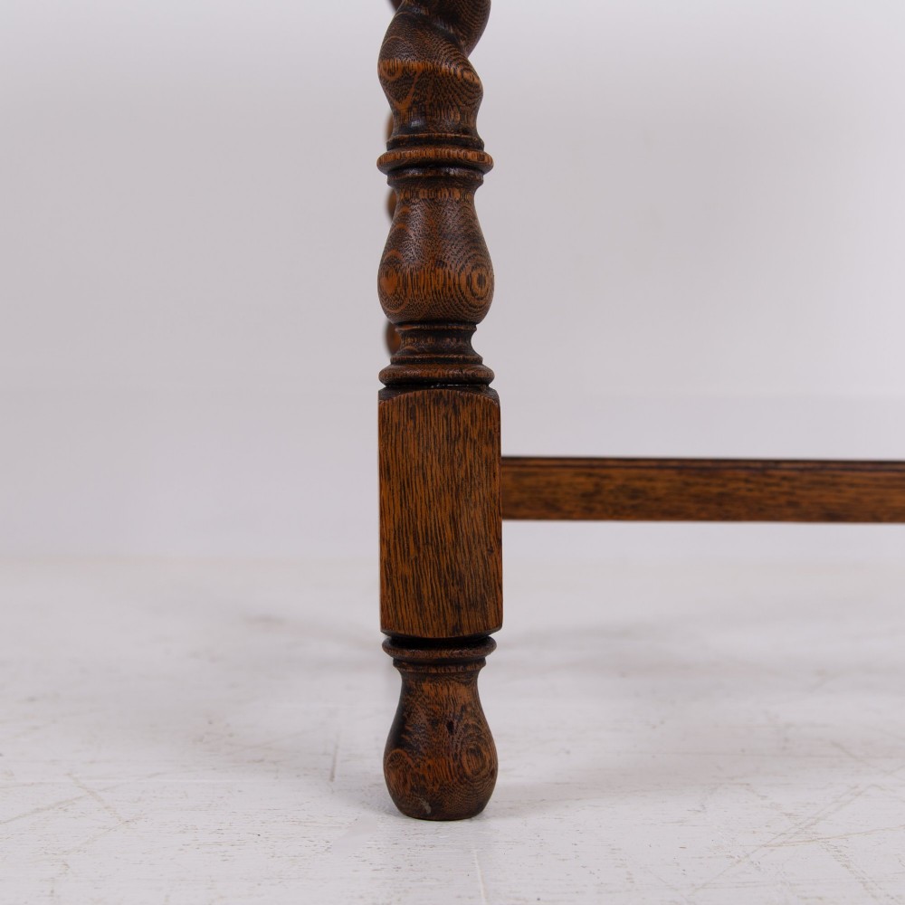 An antique English oak side table featuring a single drawer with metal drop handles, set upon four barley twist legs connected by an H-stretcher base. View VI