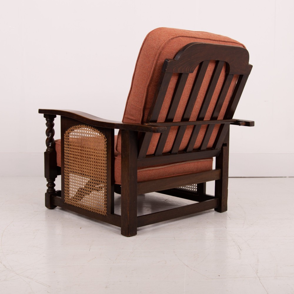 A pair of dark oak Edwardian armchairs featuring barley twist front supports, woven cane side panels, and thick terracotta fabric cushions. View VIII