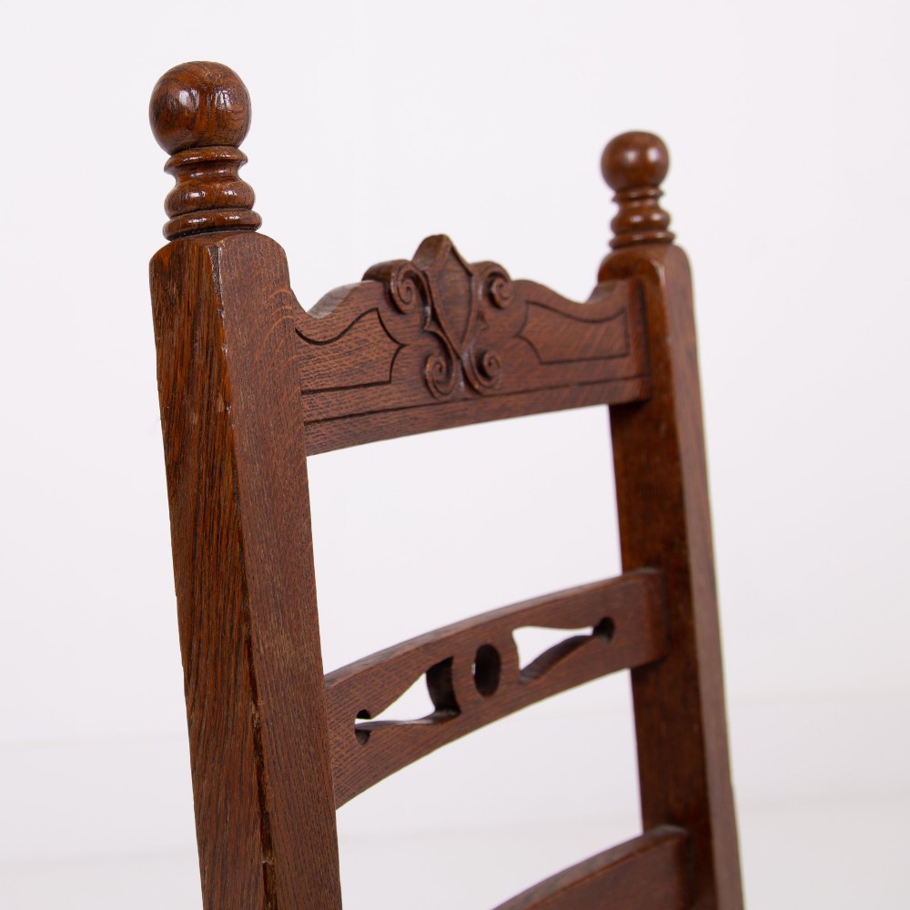 A set of six dark oak country dining chairs featuring hand-woven rush seats, carved top rails, and turned front legs. View VI