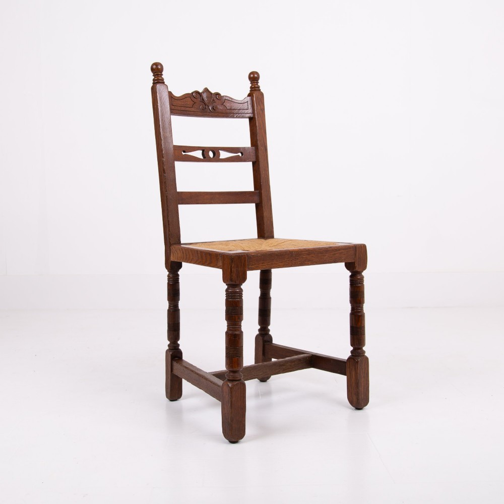A set of six dark oak country dining chairs featuring hand-woven rush seats, carved top rails, and turned front legs. View VII
