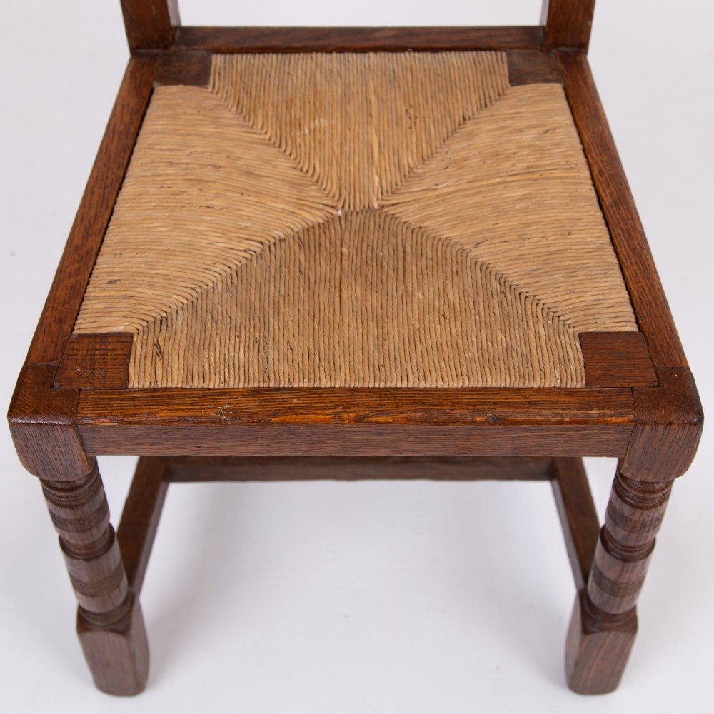 A set of six dark oak country dining chairs featuring hand-woven rush seats, carved top rails, and turned front legs. View VIII