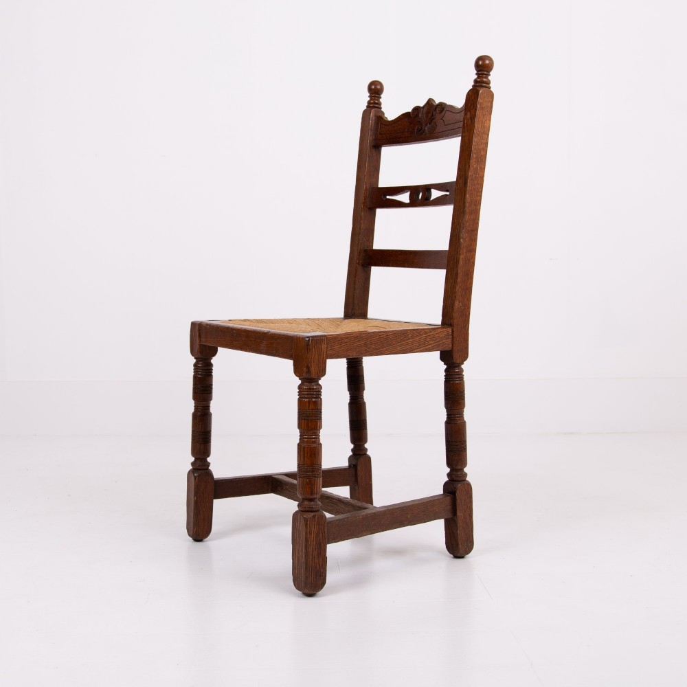A set of six dark oak country dining chairs featuring hand-woven rush seats, carved top rails, and turned front legs. View XII