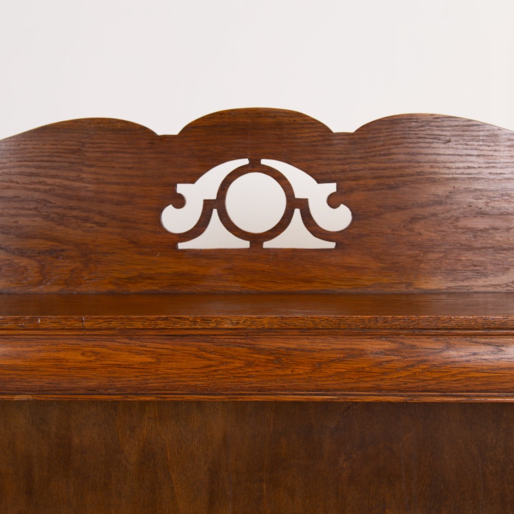 An Arts and Crafts solid oak open bookcase featuring five shelves, shaped side panels, and a decorative cresting rail with a pierced central cutout. View III