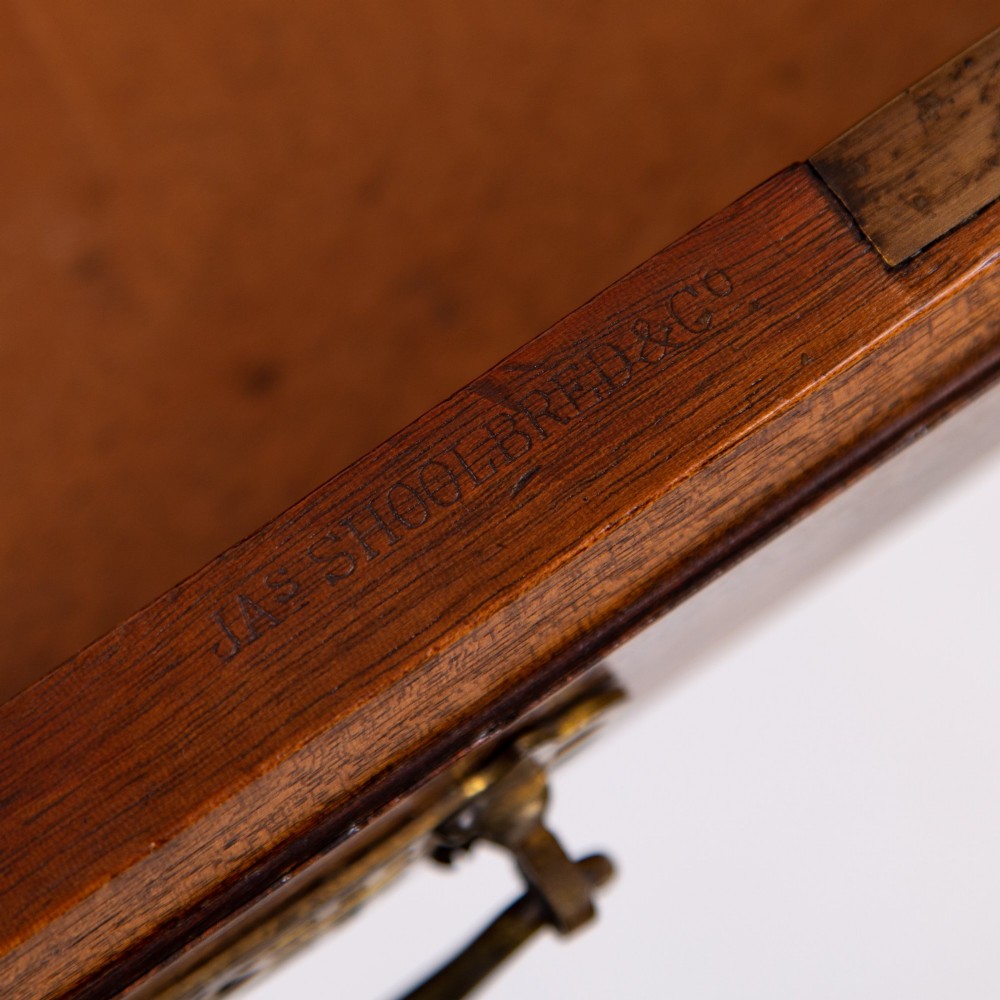 A late 19th-century walnut writing desk featuring two drawers with brass handles, turned legs on castors, and an inset leather top. View VI
