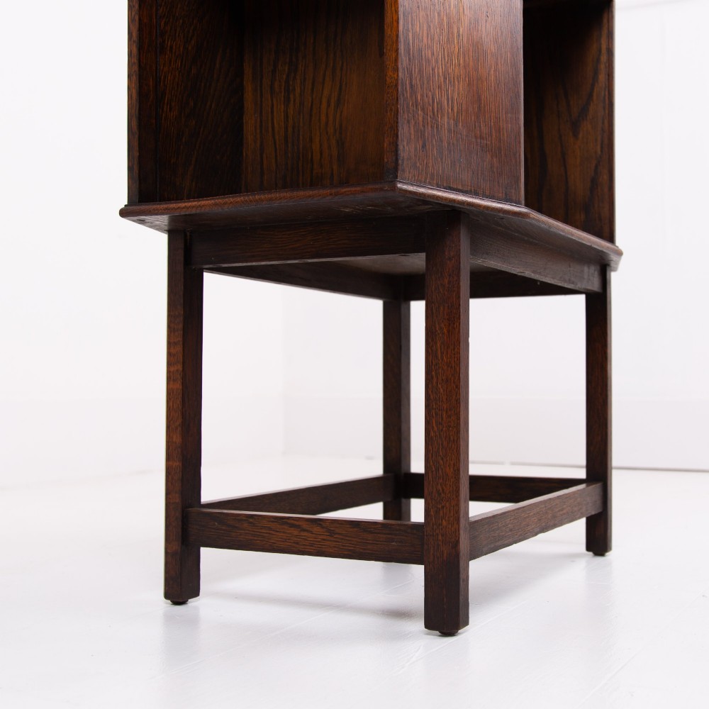 An Art Deco dark oak side table featuring an octagonal top, open central niche, side book compartments, and straight legs with square stretchers. View VIII
