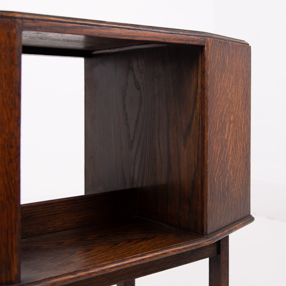 An Art Deco dark oak side table featuring an octagonal top, open central niche, side book compartments, and straight legs with square stretchers. View IX