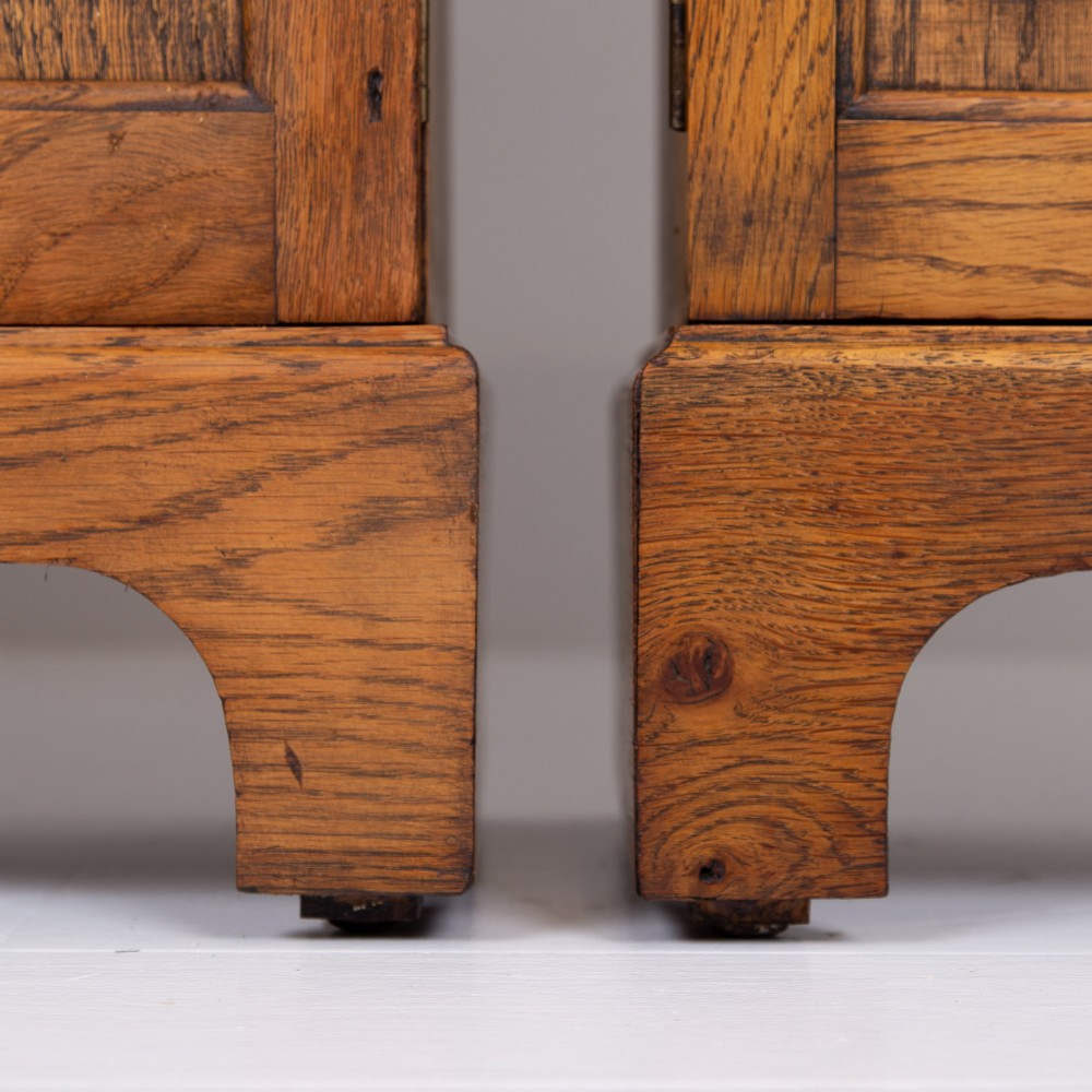 A matching pair of 1930s solid English oak bookcases featuring glazed twin doors above oval-carved lower door panels. View III