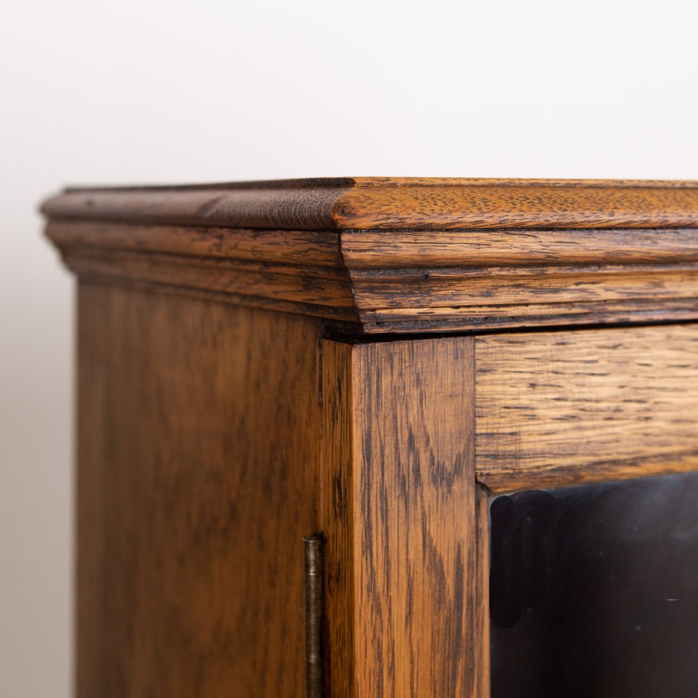 A matching pair of 1930s solid English oak bookcases featuring glazed twin doors above oval-carved lower door panels. View VIII