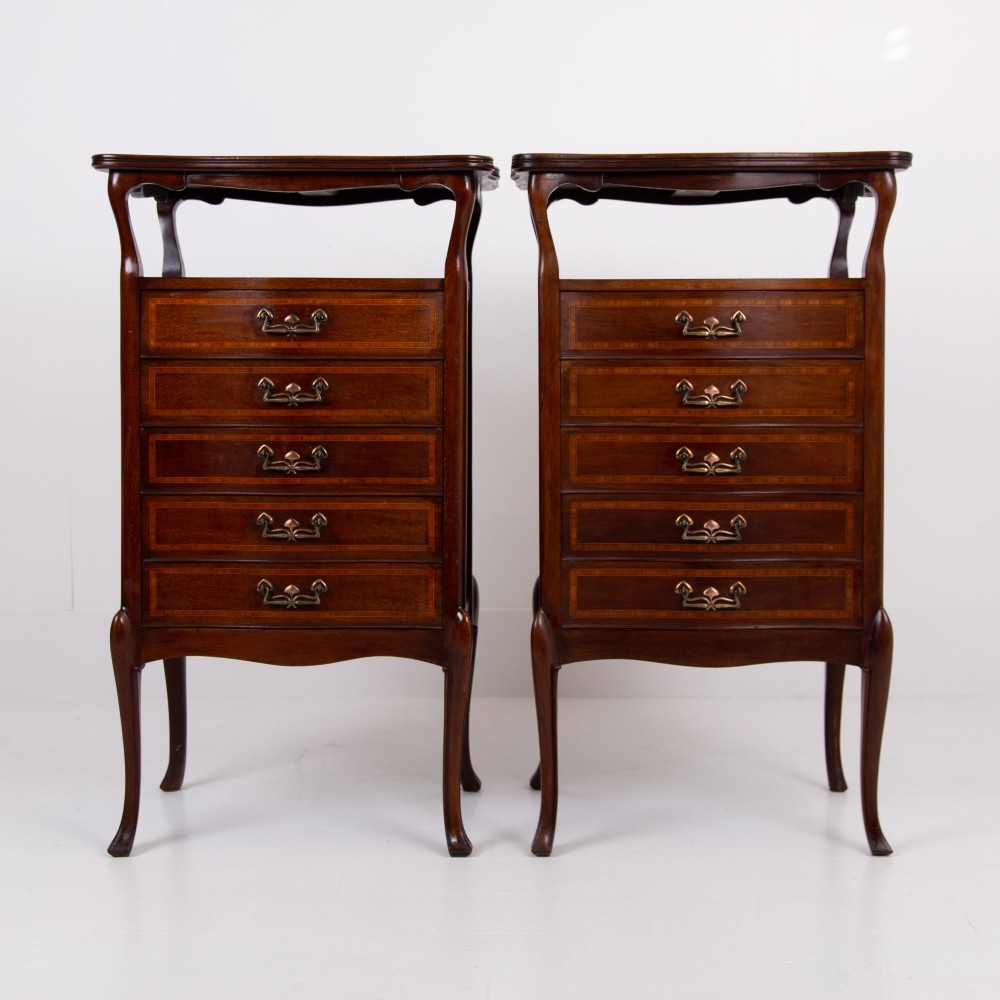 A matching pair of dark mahogany Edwardian cabinets featuring five inlaid drawers, slender cabriole legs, and an open top tray shelf. View II