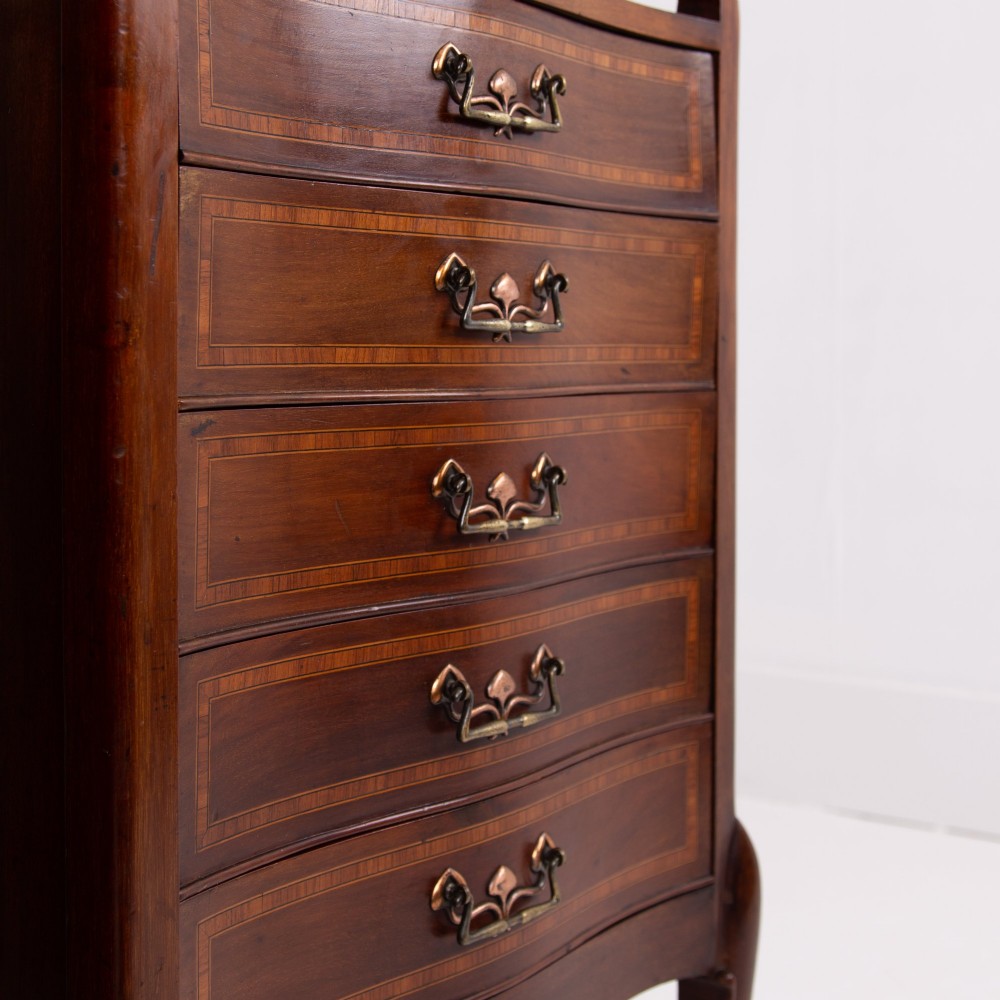 A matching pair of dark mahogany Edwardian cabinets featuring five inlaid drawers, slender cabriole legs, and an open top tray shelf. View V