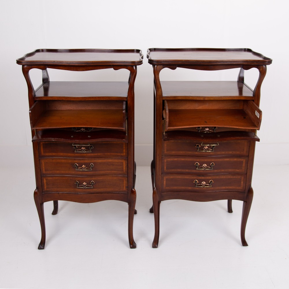 A matching pair of dark mahogany Edwardian cabinets featuring five inlaid drawers, slender cabriole legs, and an open top tray shelf. View VI
