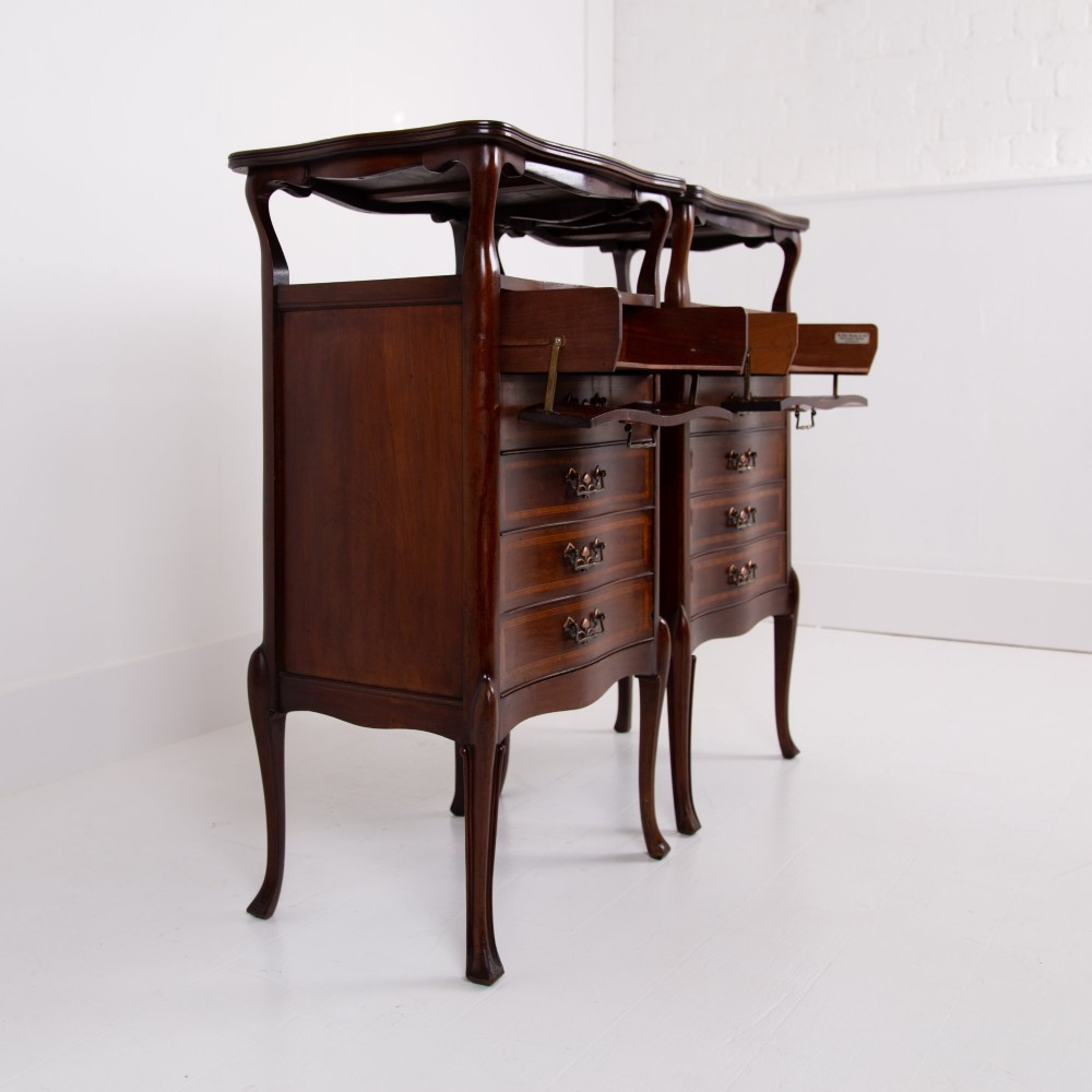A matching pair of dark mahogany Edwardian cabinets featuring five inlaid drawers, slender cabriole legs, and an open top tray shelf. View VII