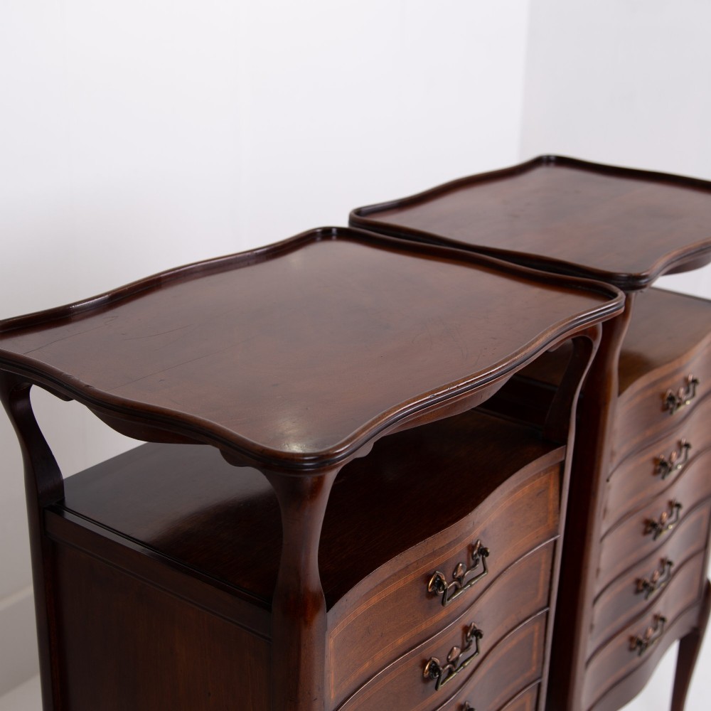 A matching pair of dark mahogany Edwardian cabinets featuring five inlaid drawers, slender cabriole legs, and an open top tray shelf. View VIII