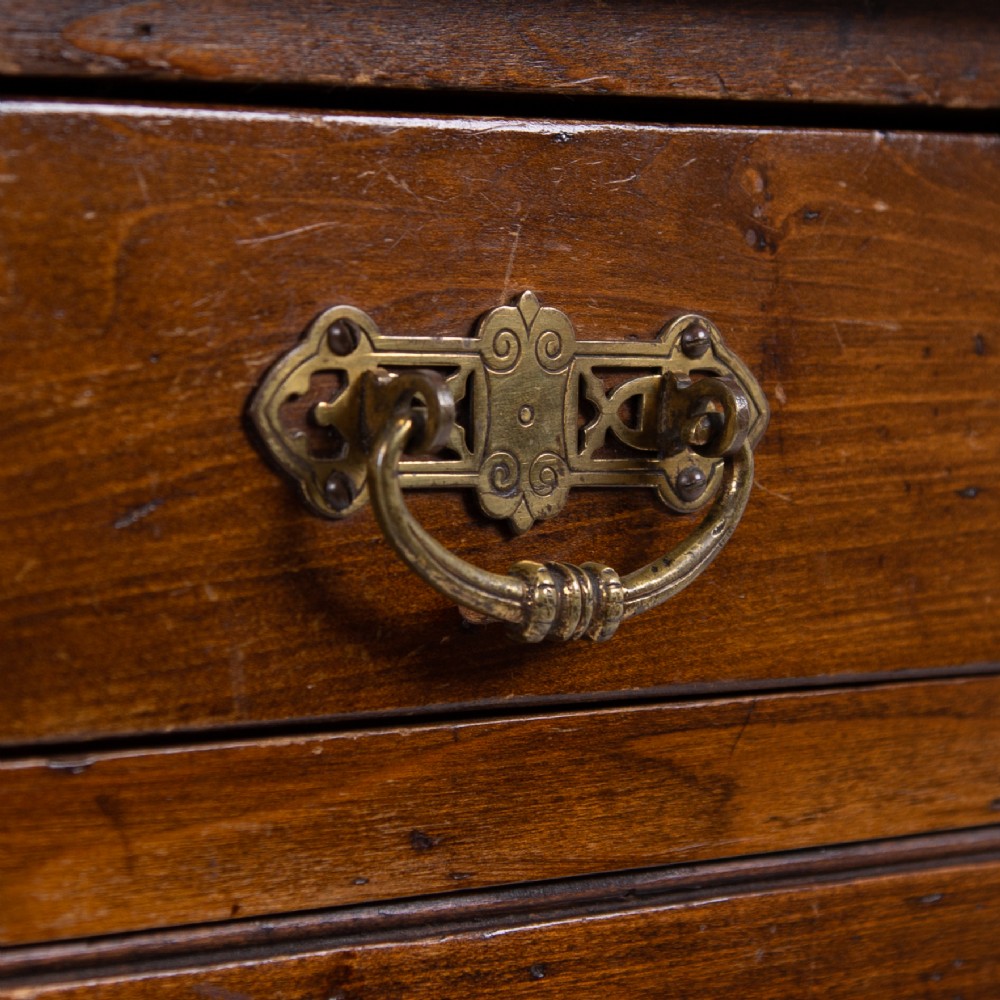 A brown walnut writing desk featuring two frieze drawers with brass handles, turned legs, and a rectangular inset leather top. View VI