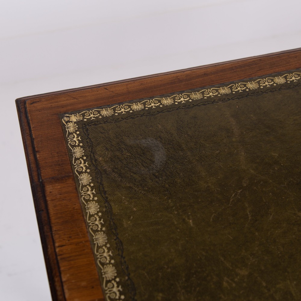 A brown walnut writing desk featuring two frieze drawers with brass handles, turned legs, and a rectangular inset leather top. View VII
