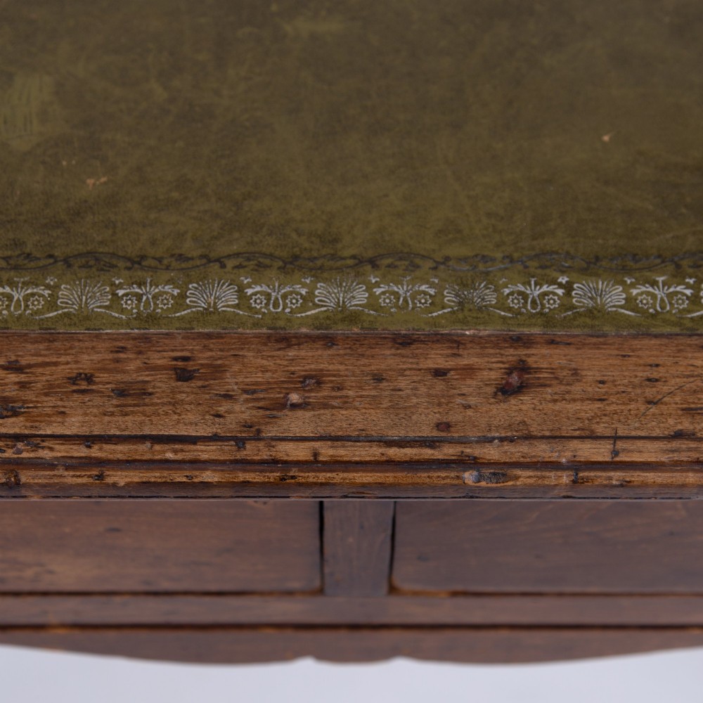 A brown walnut writing desk featuring two frieze drawers with brass handles, turned legs, and a rectangular inset leather top. View IX