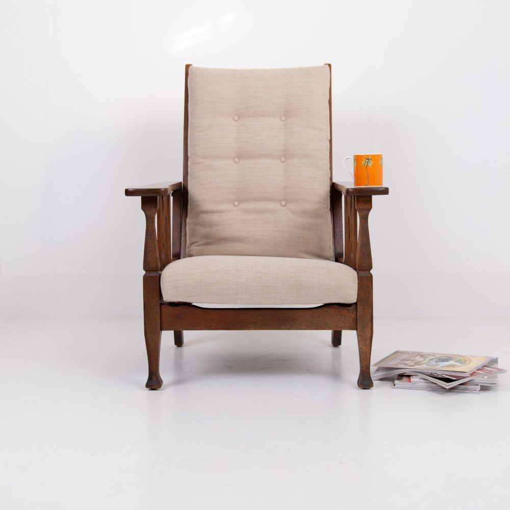 An Arts and Crafts oak reclining armchair featuring a beige buttoned cushion and pierced side splats. View XII