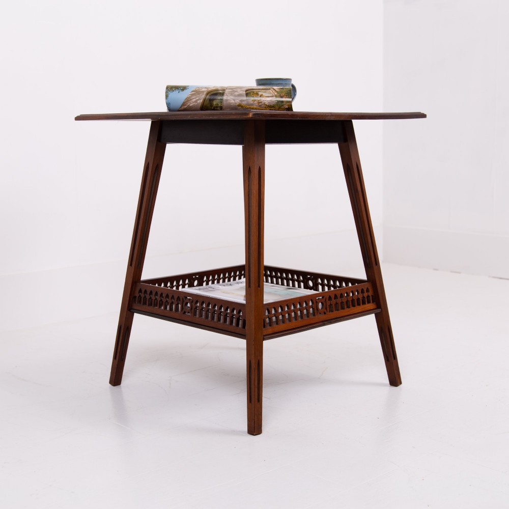 A late Victorian two-tier walnut side table featuring square splayed legs and a lower shelf enclosed by a pierced fretwork gallery.