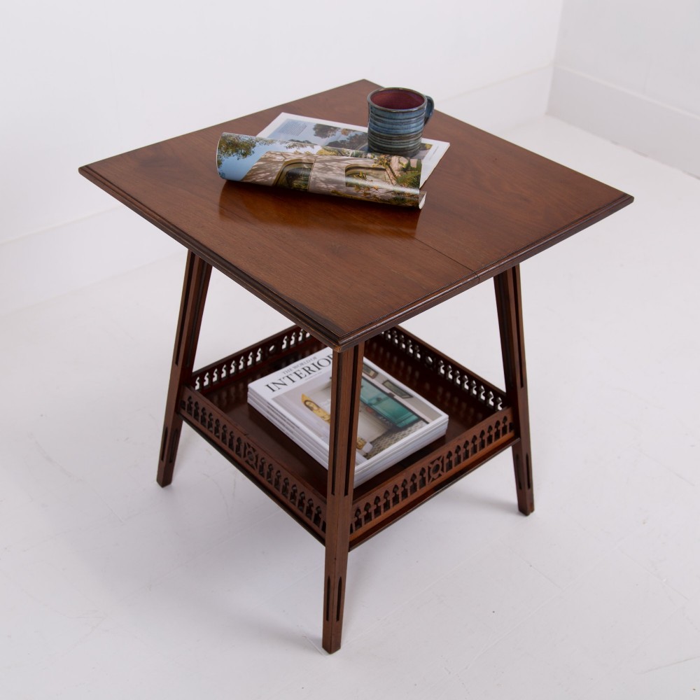 A late Victorian two-tier walnut side table featuring square splayed legs and a lower shelf enclosed by a pierced fretwork gallery. View II